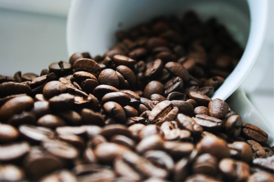 coffee beans spilled out of white mug